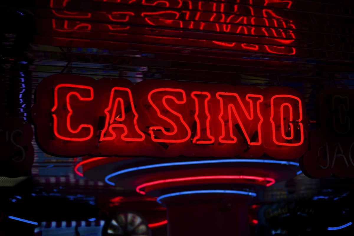 Suasana kasino dengan lampu neon merah dan tanda Casino